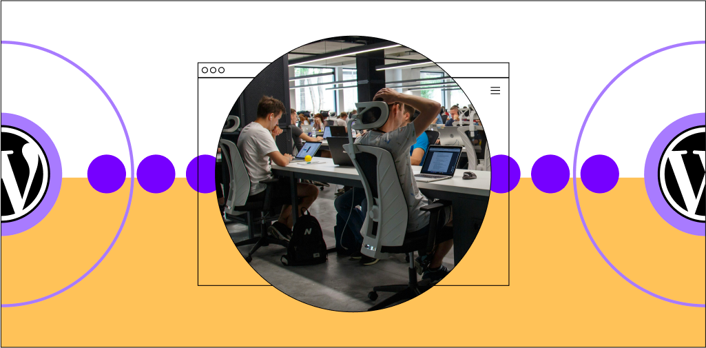 Workers at a table working on laptops in a workspace